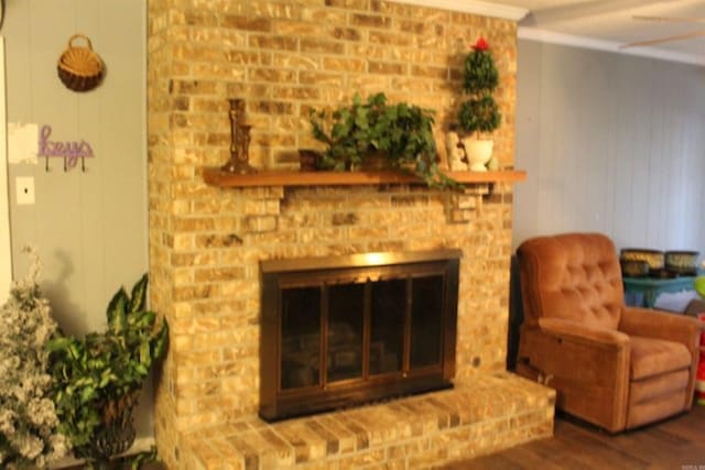 living room with wood finished floors, a fireplace, and crown molding