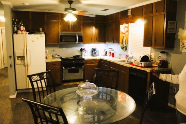 kitchen with stainless steel microwave, range with gas stovetop, black dishwasher, white refrigerator with ice dispenser, and light countertops