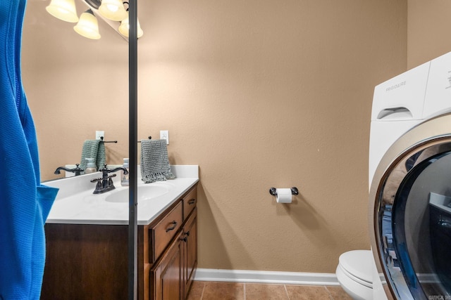 bathroom with toilet, washer / clothes dryer, vanity, and baseboards