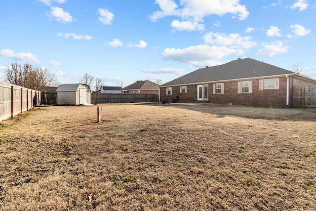 view of yard with an outbuilding, a storage shed, and a fenced backyard