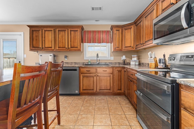 kitchen featuring brown cabinets, visible vents, appliances with stainless steel finishes, and a sink