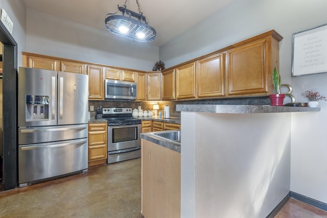 kitchen with finished concrete flooring, a peninsula, stainless steel appliances, decorative backsplash, and dark countertops