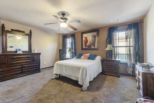 carpeted bedroom featuring visible vents, baseboards, and a ceiling fan