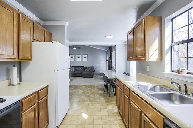 kitchen with crown molding, ceiling fan, open floor plan, light countertops, and a sink