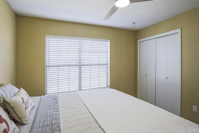 bedroom featuring a ceiling fan, a closet, and a textured ceiling