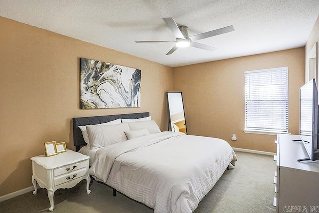 bedroom with a ceiling fan, baseboards, carpet floors, and a textured ceiling