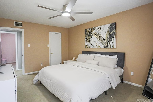 bedroom with visible vents, light carpet, baseboards, and ceiling fan