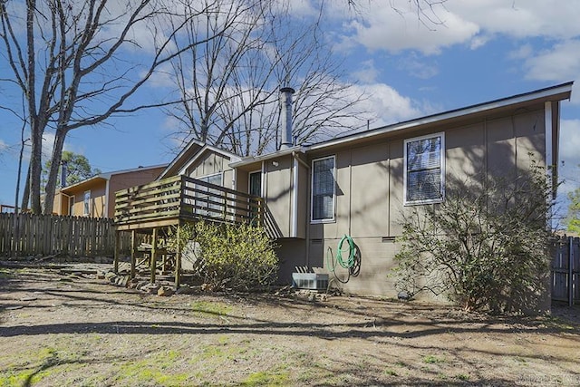 rear view of property with cooling unit, a wooden deck, and fence