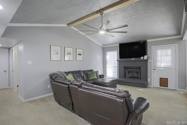 carpeted living room featuring lofted ceiling with beams, plenty of natural light, a brick fireplace, and a ceiling fan