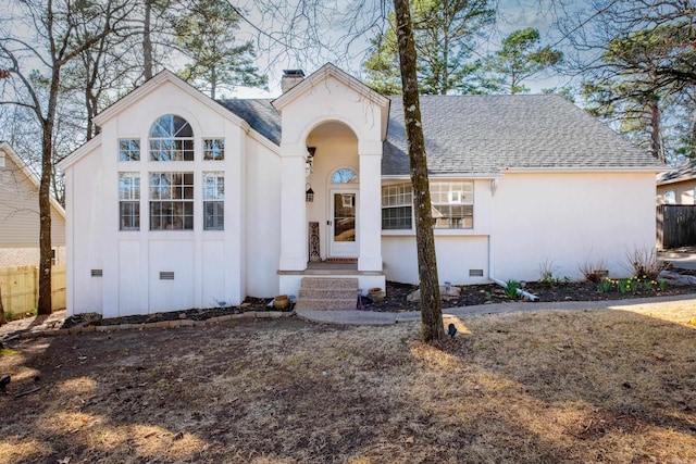 view of front of home featuring crawl space, stucco siding, a chimney, and a shingled roof