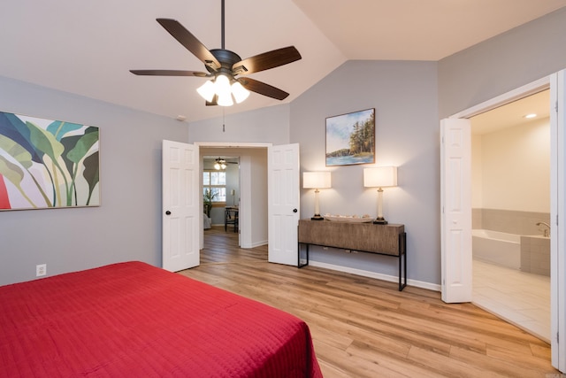 bedroom with lofted ceiling, ensuite bathroom, a ceiling fan, light wood-style floors, and baseboards