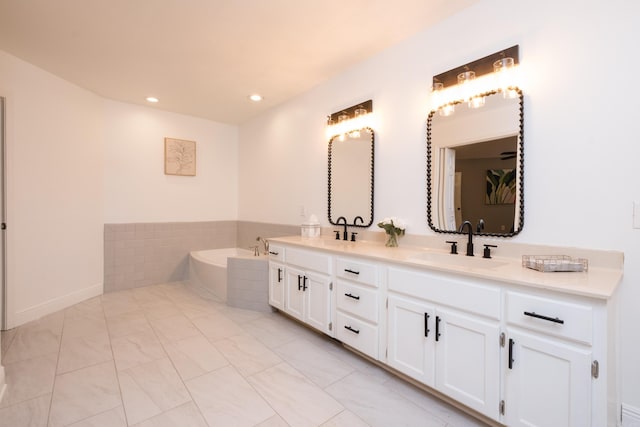 full bathroom with a bath, recessed lighting, double vanity, and a sink