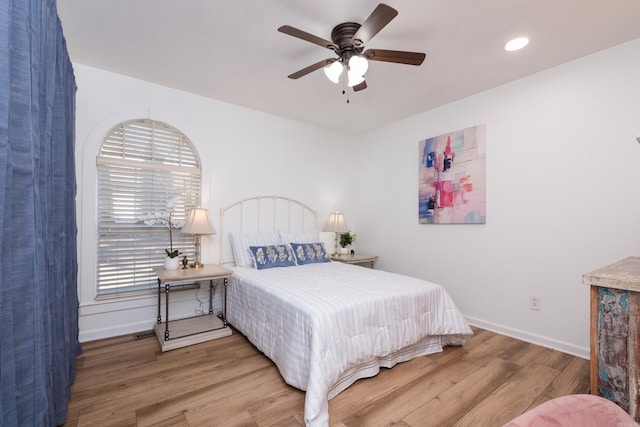 bedroom with a ceiling fan, baseboards, and wood finished floors