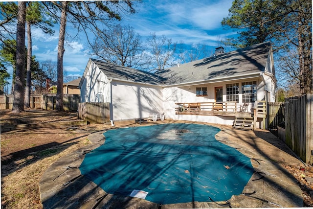 back of property with roof with shingles, a fenced backyard, and a chimney