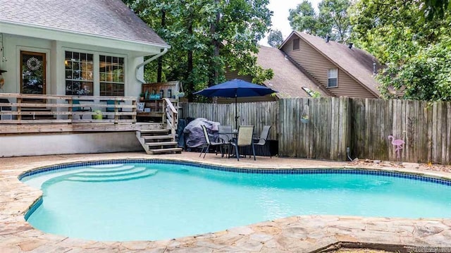 view of pool with a patio area, a deck, a fenced in pool, and a fenced backyard