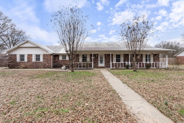 ranch-style house with metal roof, brick siding, and a porch