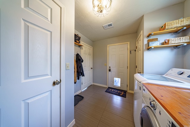 clothes washing area with baseboards, visible vents, laundry area, a textured ceiling, and independent washer and dryer