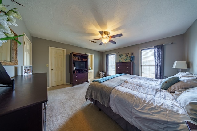 bedroom featuring light carpet, a textured ceiling, and ceiling fan