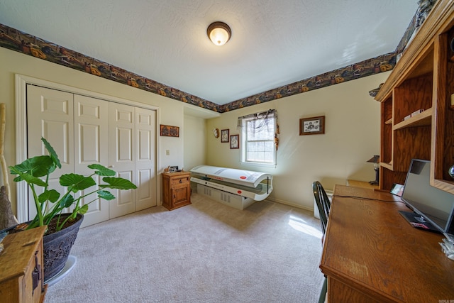 bedroom featuring a closet, light carpet, and a textured ceiling