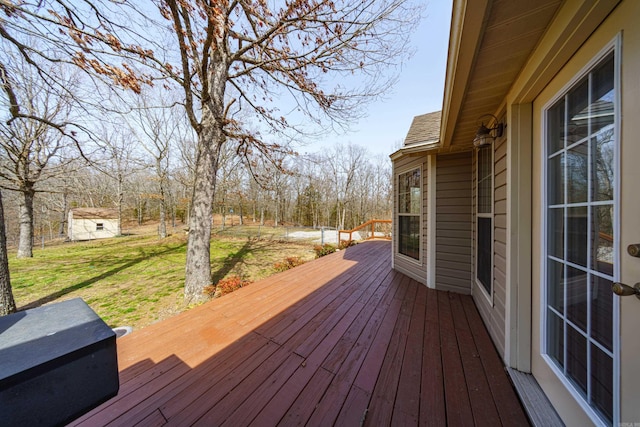 wooden terrace with an outdoor structure and a yard