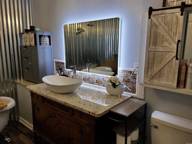 bathroom with decorative backsplash, toilet, and vanity