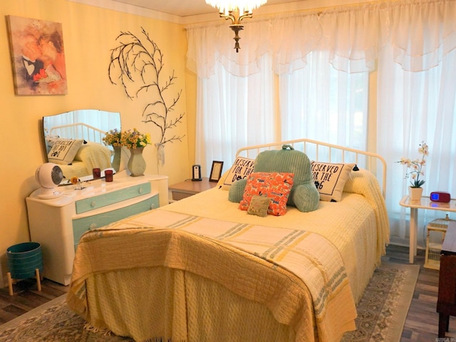 bedroom with wood finished floors and a chandelier