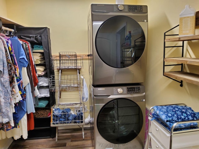 laundry room featuring laundry area, stacked washer / drying machine, and wood finished floors