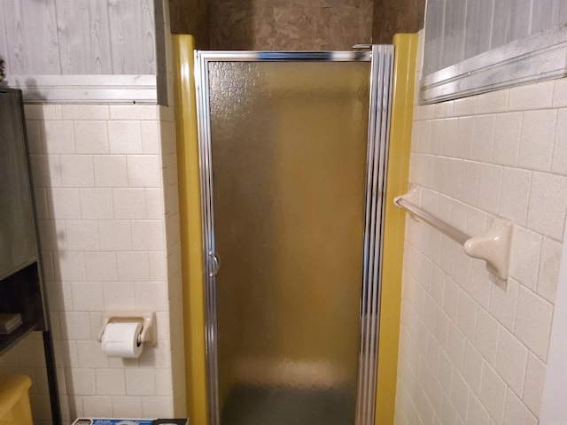 full bath featuring a stall shower and tile walls