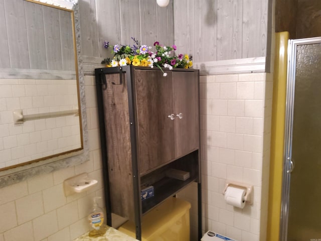 bathroom featuring tile walls, toilet, and a stall shower