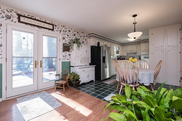 kitchen with oven, pendant lighting, stainless steel refrigerator with ice dispenser, french doors, and wallpapered walls