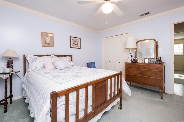 carpeted bedroom featuring visible vents, baseboards, ornamental molding, a closet, and a ceiling fan