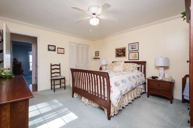 carpeted bedroom featuring crown molding, a ceiling fan, and a closet