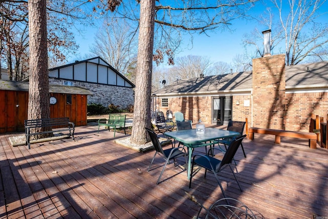 deck with outdoor dining space and an outdoor structure