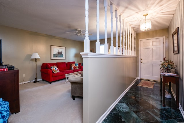 hallway featuring an inviting chandelier, baseboards, and carpet floors