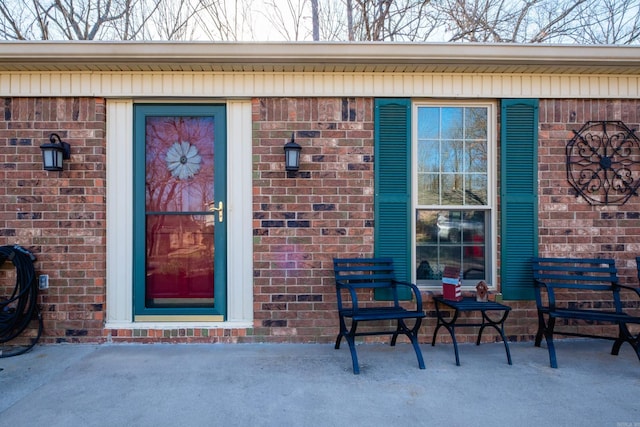 doorway to property featuring brick siding