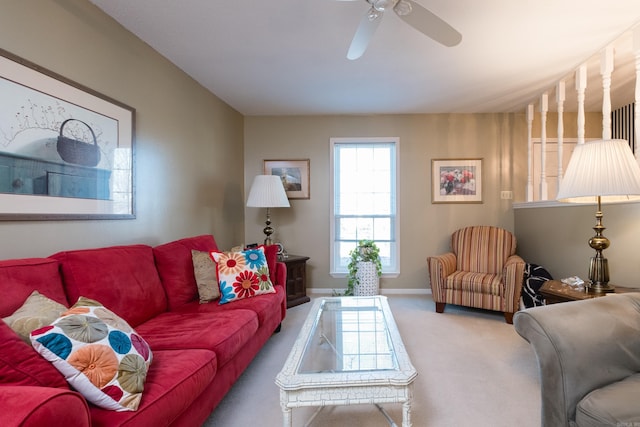 carpeted living area featuring baseboards and a ceiling fan