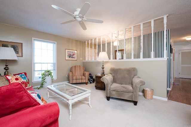 carpeted living room with a ceiling fan and baseboards