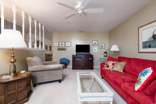 carpeted living room with visible vents, baseboards, and a ceiling fan