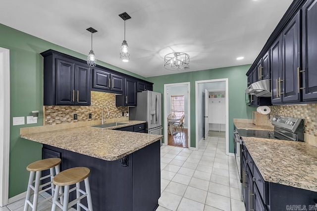 kitchen with under cabinet range hood, a breakfast bar area, appliances with stainless steel finishes, a peninsula, and a sink