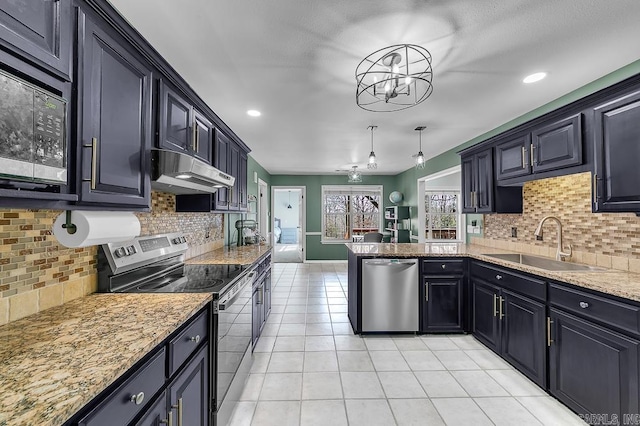 kitchen with under cabinet range hood, a sink, a peninsula, appliances with stainless steel finishes, and light tile patterned floors