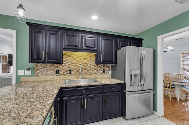 kitchen with decorative backsplash, crown molding, stainless steel refrigerator with ice dispenser, and a sink