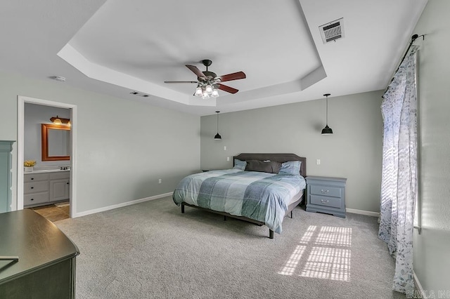 carpeted bedroom featuring visible vents, baseboards, and a tray ceiling