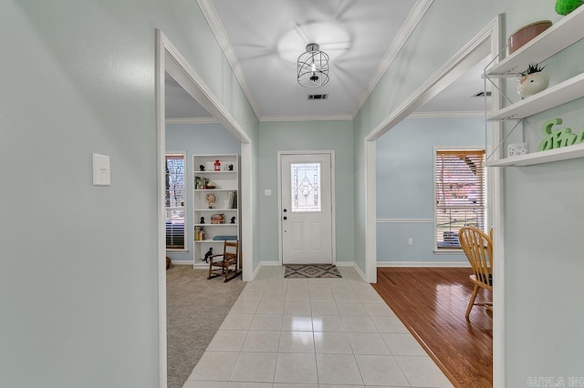 entrance foyer featuring light tile patterned floors, visible vents, baseboards, and ornamental molding