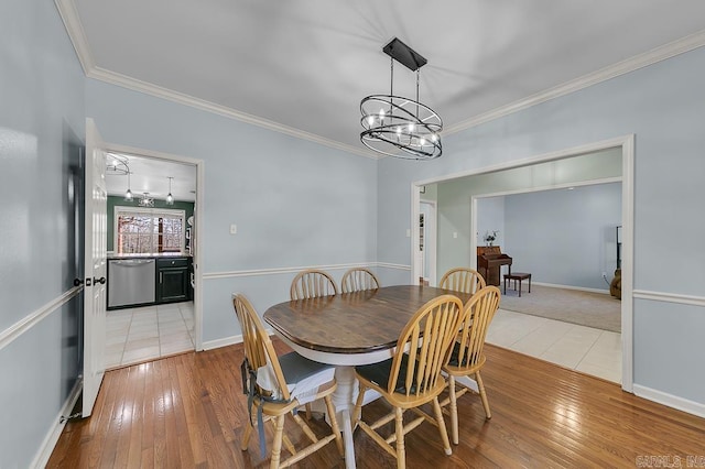 dining space featuring light wood-style floors, an inviting chandelier, and ornamental molding