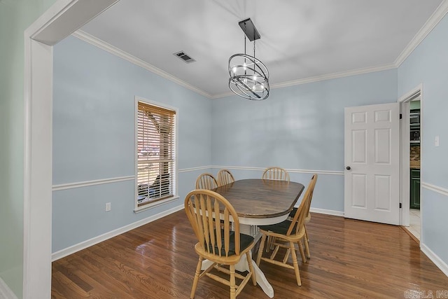 dining area featuring baseboards, wood finished floors, visible vents, and ornamental molding