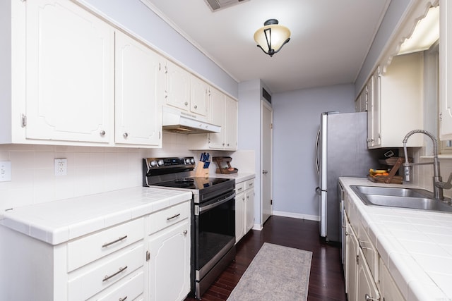 kitchen with under cabinet range hood, tile countertops, stainless steel range with electric cooktop, and a sink