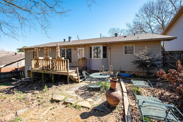 rear view of property with a deck and fence