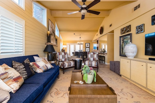 living room featuring wooden walls, vaulted ceiling with beams, ceiling fan with notable chandelier, and visible vents