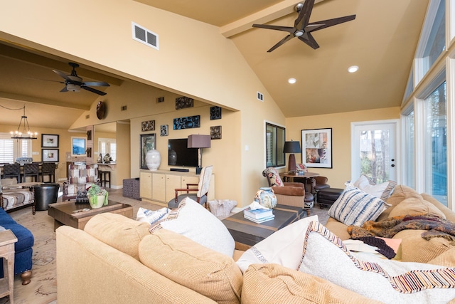 living area with a wealth of natural light, visible vents, beamed ceiling, and ceiling fan with notable chandelier