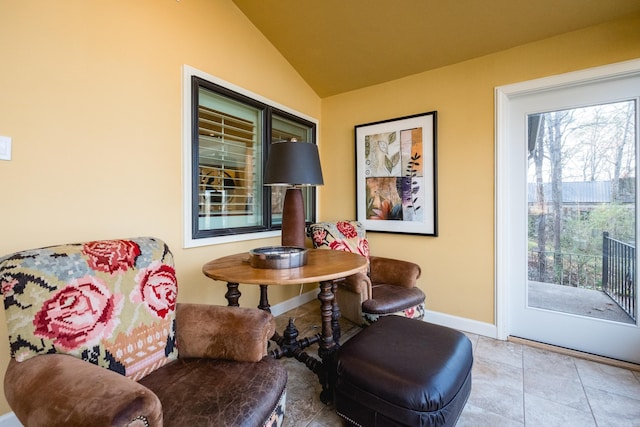 living area with vaulted ceiling, baseboards, and tile patterned floors